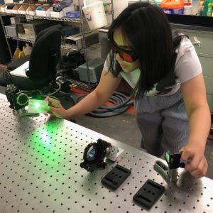 A student aligning a laser in a lab at Fordham